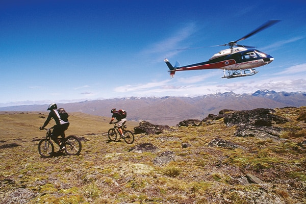 Helicopter Hovering Over Mountain Bikers